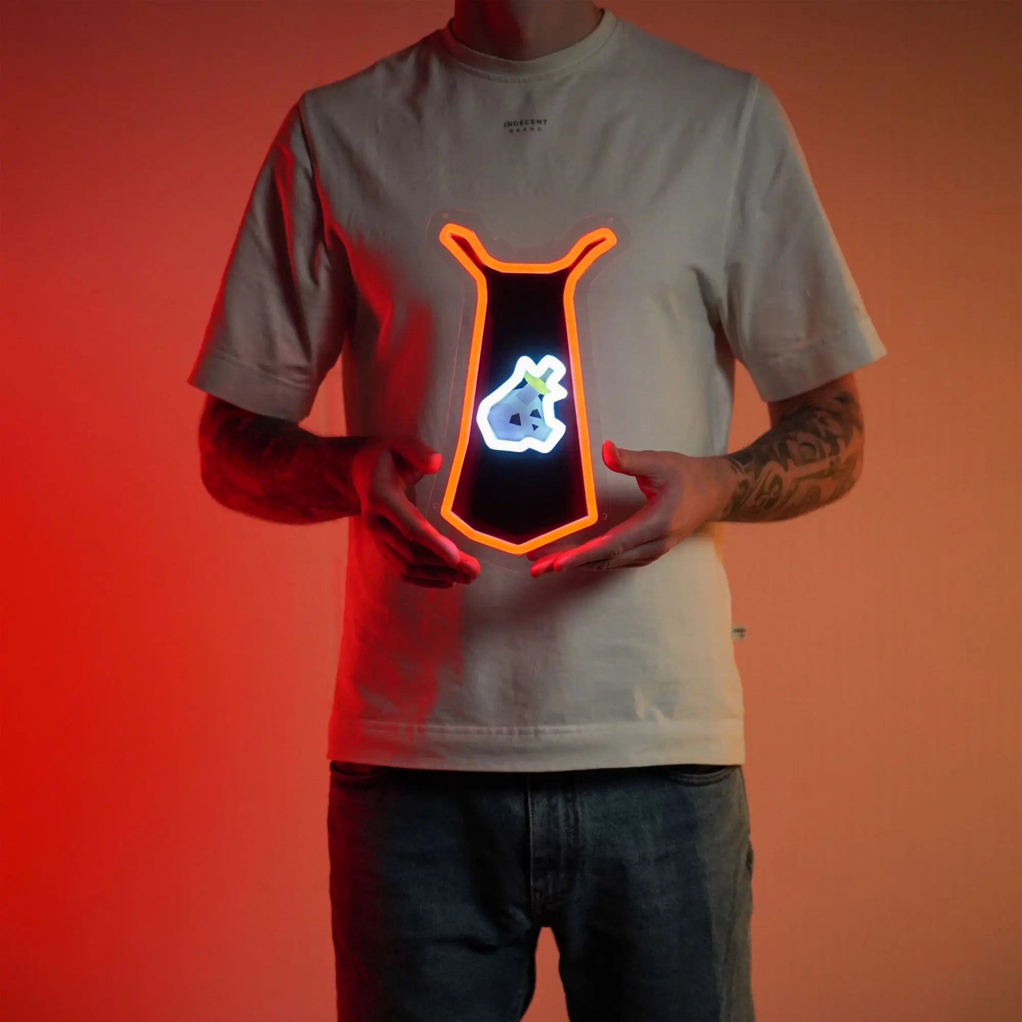 A person proudly displays the Runescape Slayer Skillcape LED neon sign, featuring the iconic Slayer skillcape from the game. This LED neon sign symbolizes the expertise and prowess of slayers in RuneScape. A symbol of adventure and combat mastery, it adds a touch of excitement to any gaming space.