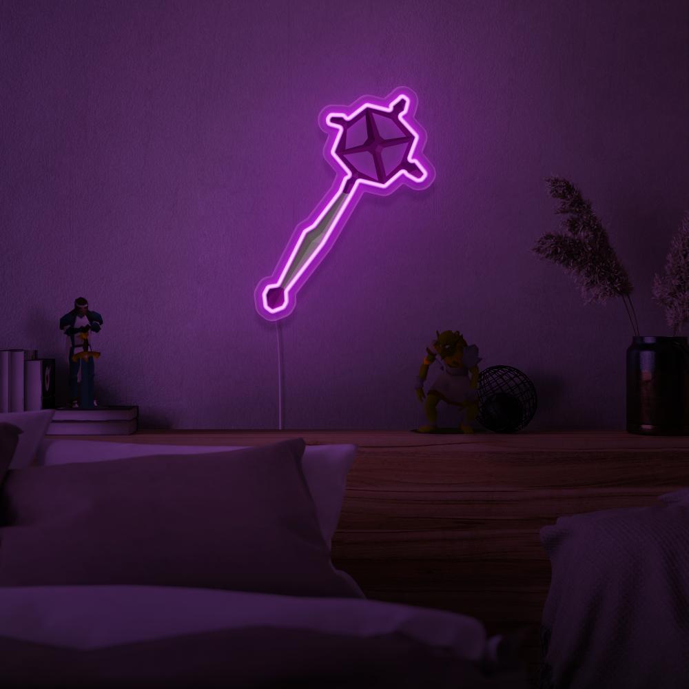 Immerse yourself in the world of magic with the OSRS Ancient Staff LED neon sign mounted above a sleeping bed. This LED neon sign, featuring the iconic ancient staff from Old School RuneScape, creates a serene and mystical atmosphere for rest and relaxation.