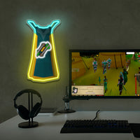 Runescape fletching cape neon sign shaped like a arrow on a wall above a computer setup with a monitor displaying a game.