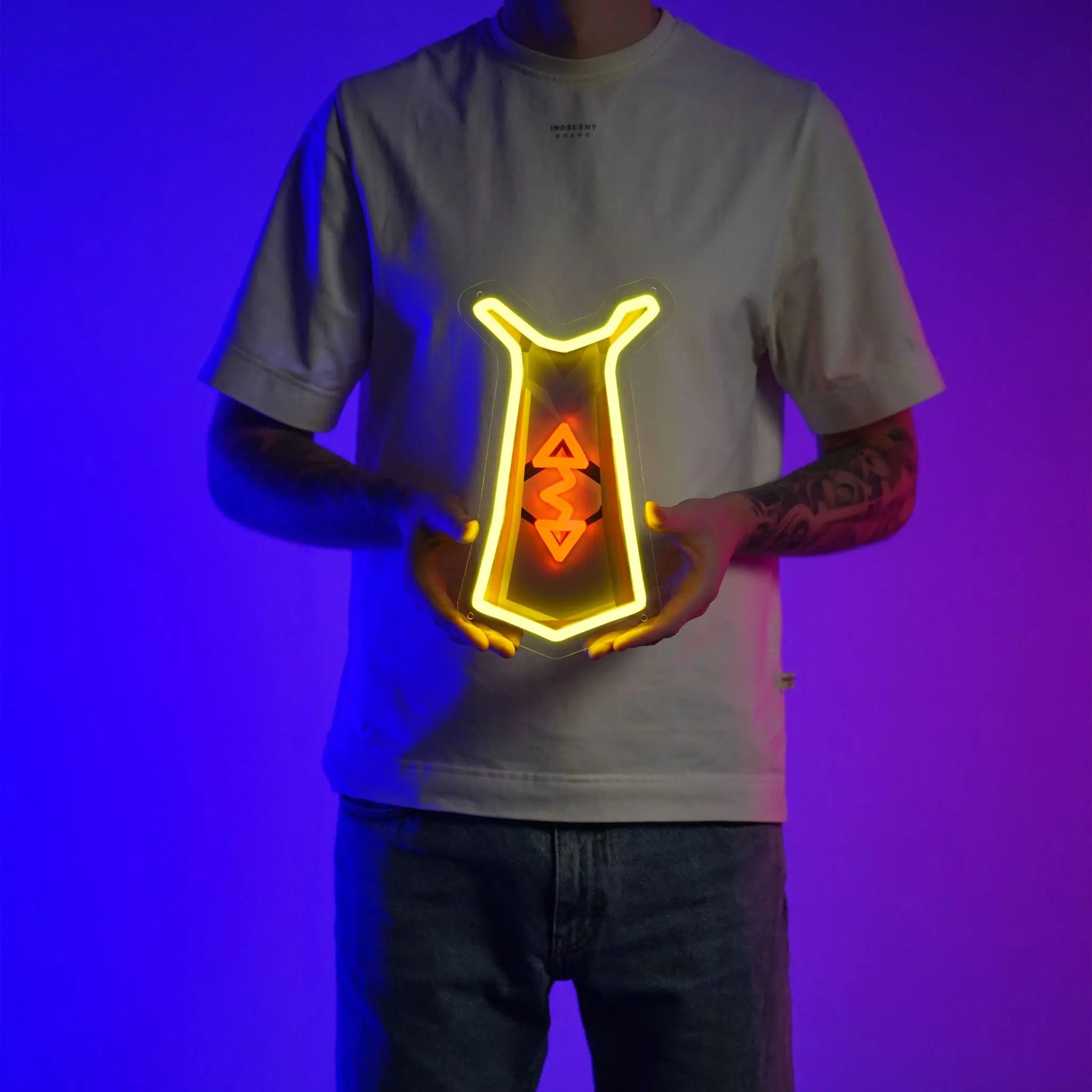 A person proudly displays the Runescape Runecrafting Skillcape LED neon sign, featuring the iconic Runecrafting skillcape from the game. This LED neon sign symbolizes the mastery and expertise of runecrafters in RuneScape. A symbol of magic and creativity, it adds a touch of enchantment to any gaming space.