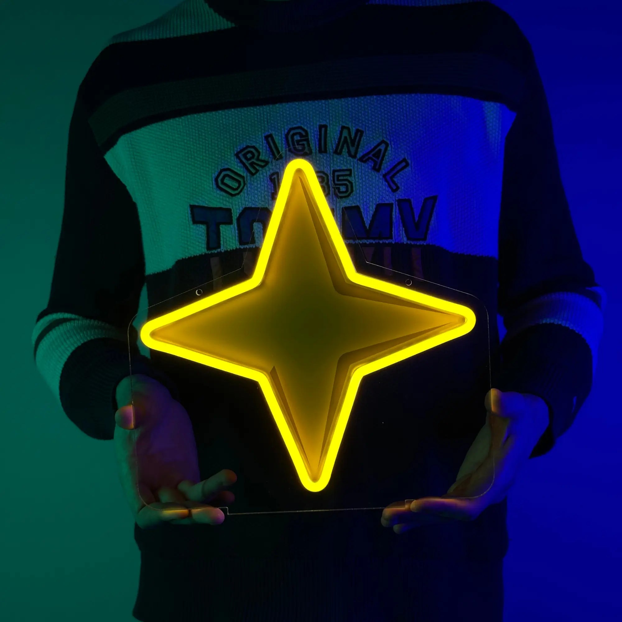 A man proudly holding a LED neon sign of the Saradomin God Symbol, an iconic emblem from Runescape.