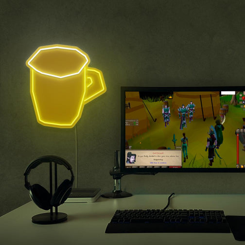 Enhance your gaming setup with the OSRS Beer Glass LED neon sign placed next to a gaming PC. This LED neon sign, featuring the iconic beer glass from Old School RuneScape, adds a touch of fun and relaxation to your gaming space.