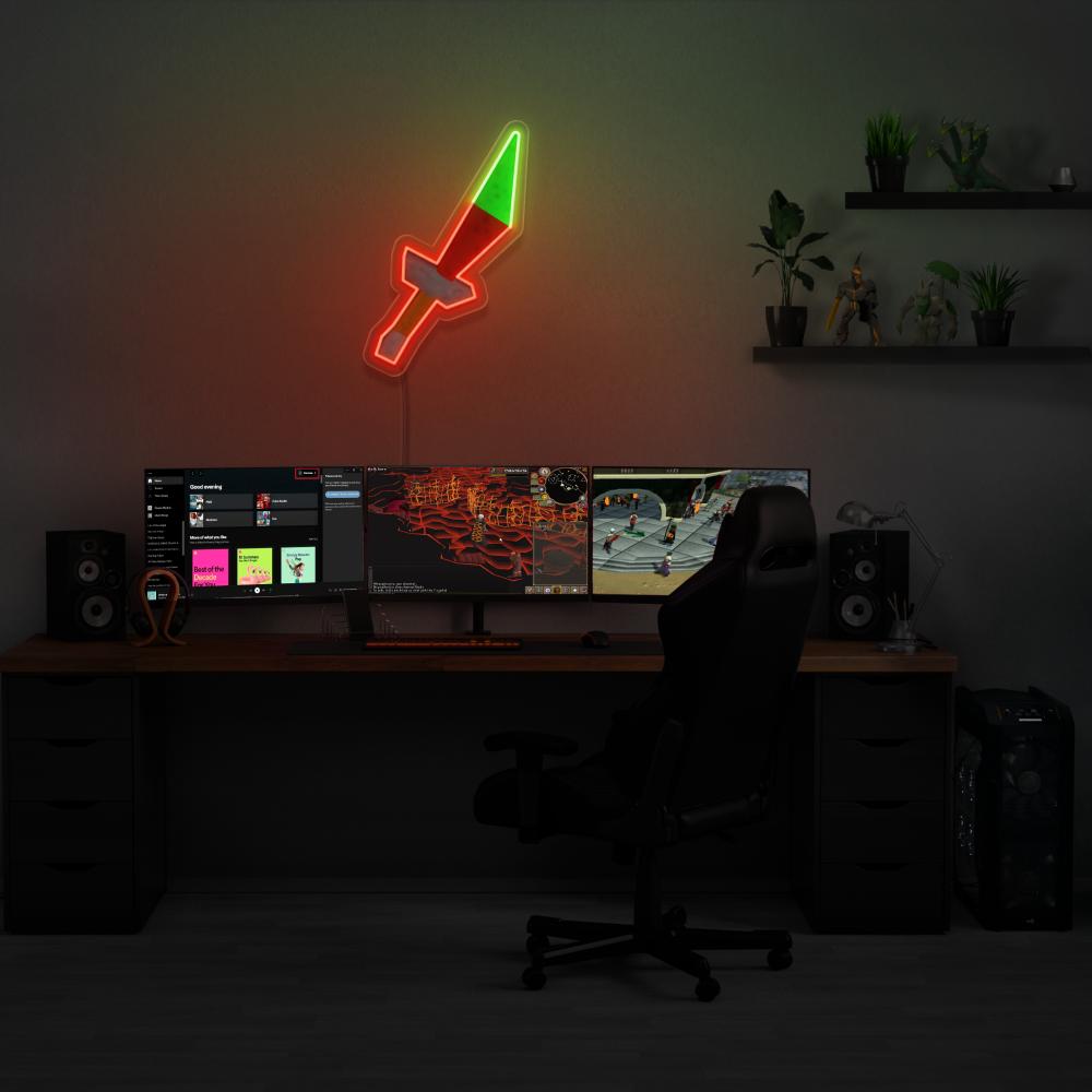 Illuminate your gaming setup with the OSRS Dragon Dagger LED neon sign mounted above a gaming PC. Featuring the iconic dagger symbol from the game, this LED neon sign adds a sense of excitement to your gaming environment, evoking memories of your adventures in RuneScape.