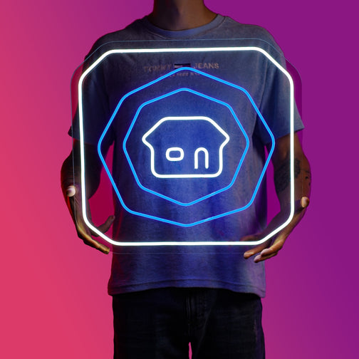 A person proudly displays the OSRS Home Tablet LED neon sign, featuring the iconic home teleport tablet from the game. This LED neon sign adds a touch of nostalgia to any gaming space. A unique and practical gift for OSRS enthusiasts. 